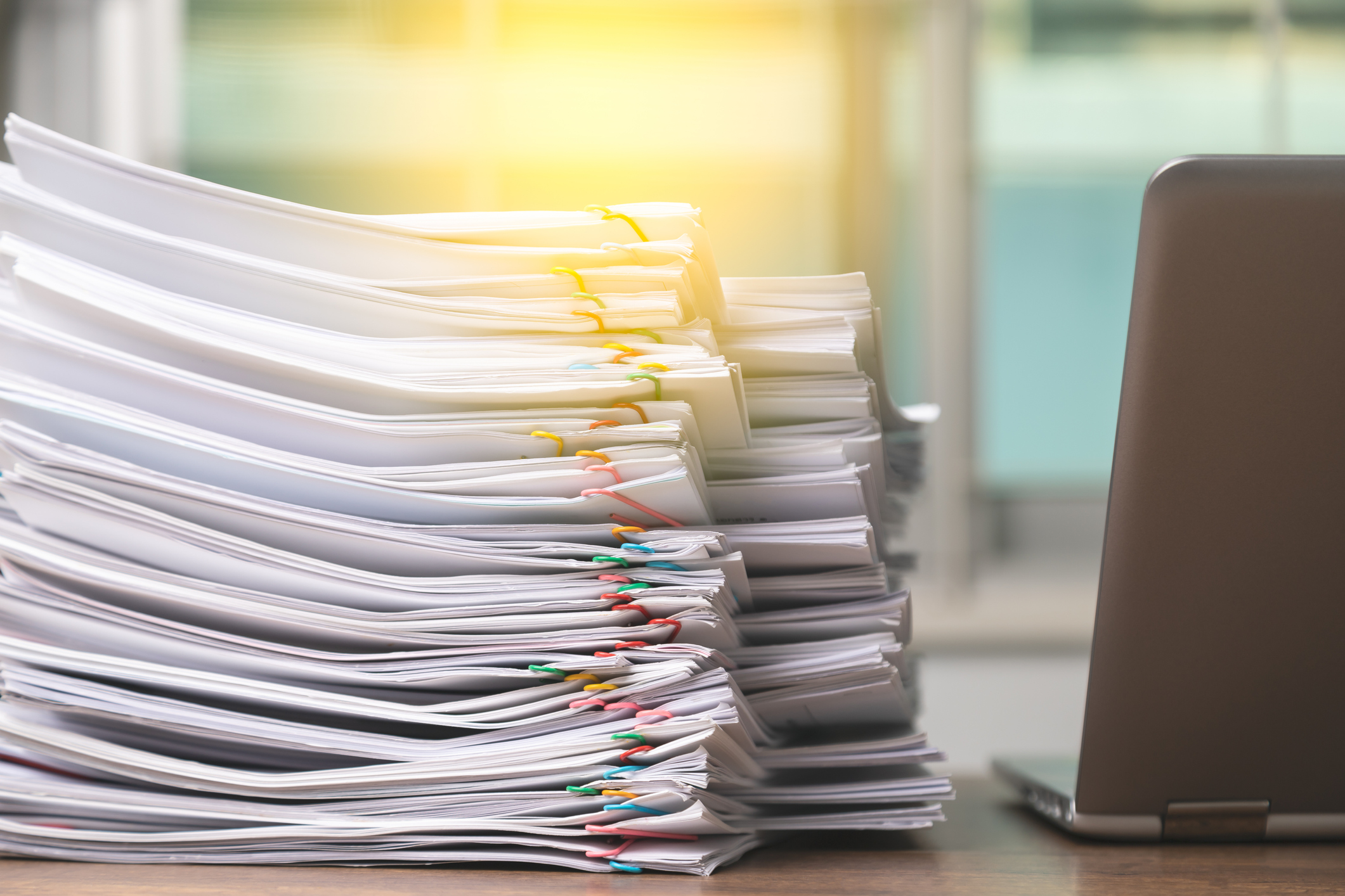 Big stack of life settlement tax paperwork and policy information.